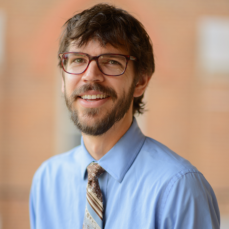 Portrait of a bearded man in a shirt and tie.