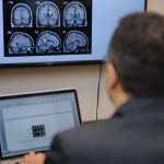 Man sitting at a desk looking at brain images