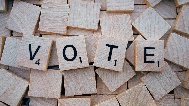 Scrabble tiles spelling out vote