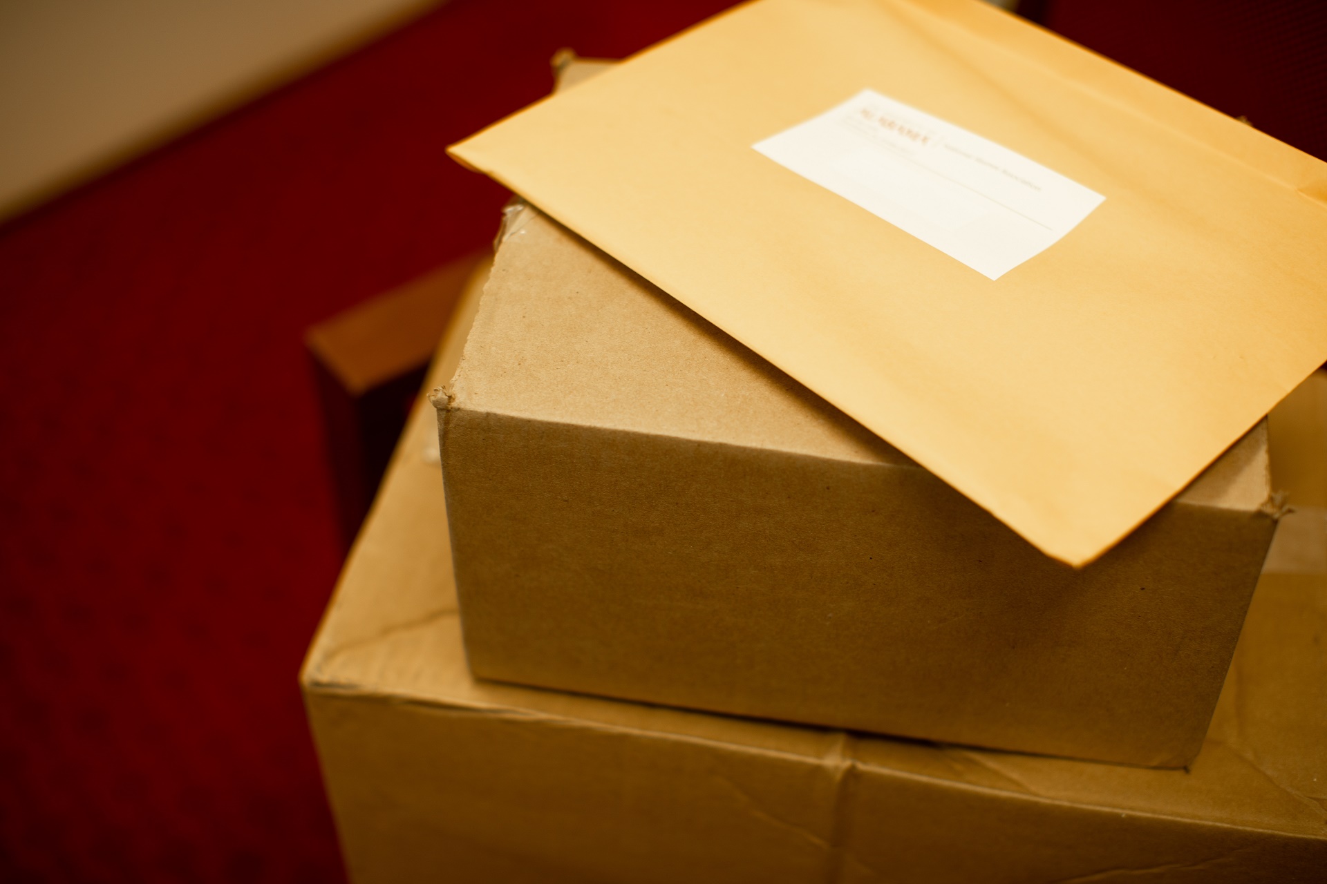 Two packages and an envelope stacked atop one another.