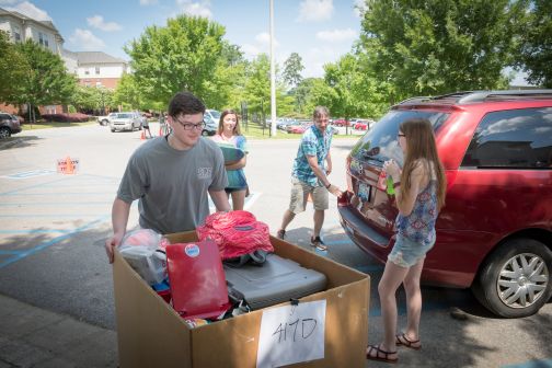 students moving belongings from cars to dorms