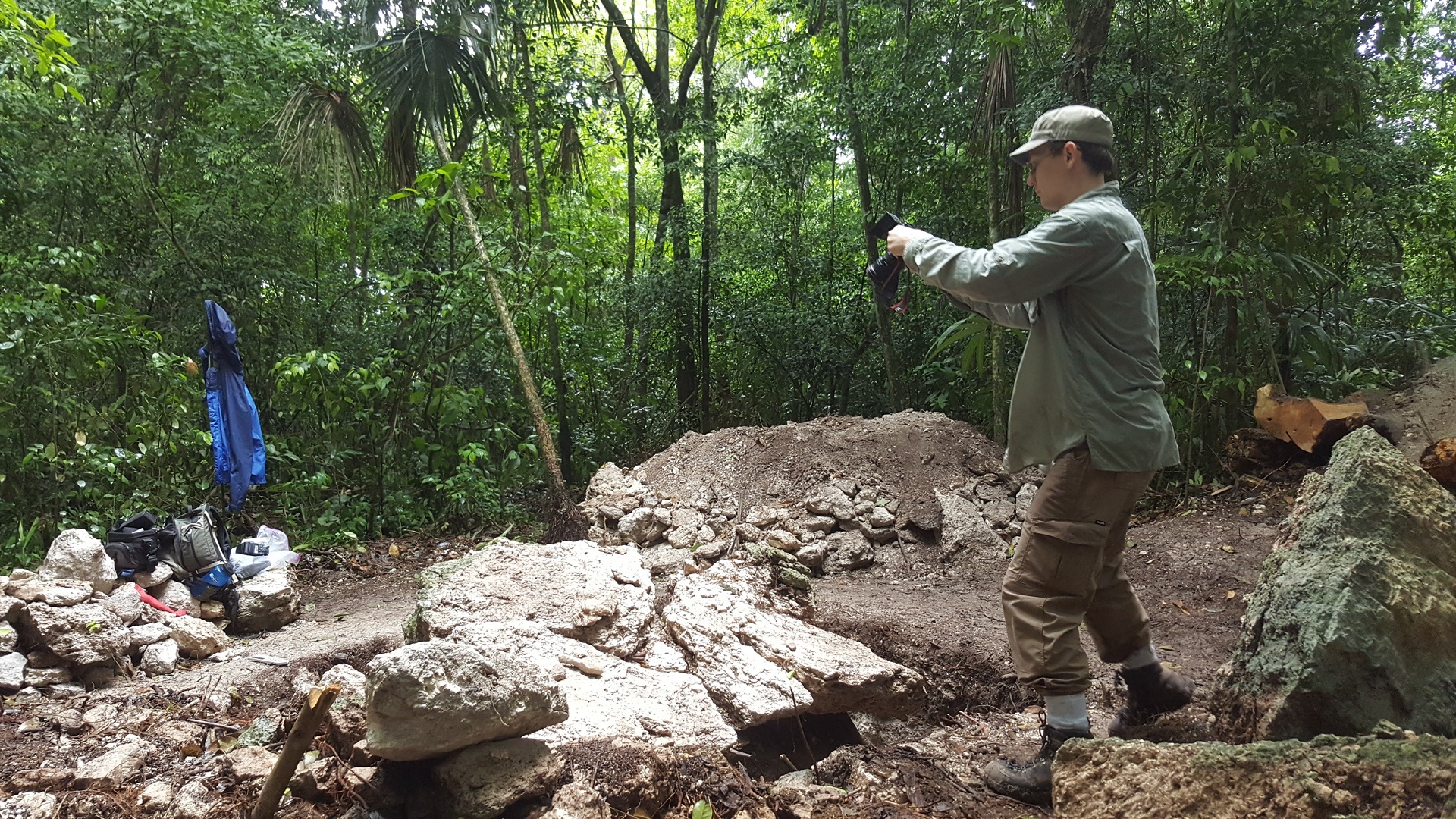A professor at The University of Alabama photographs an archaeological site of Mayan ruins.