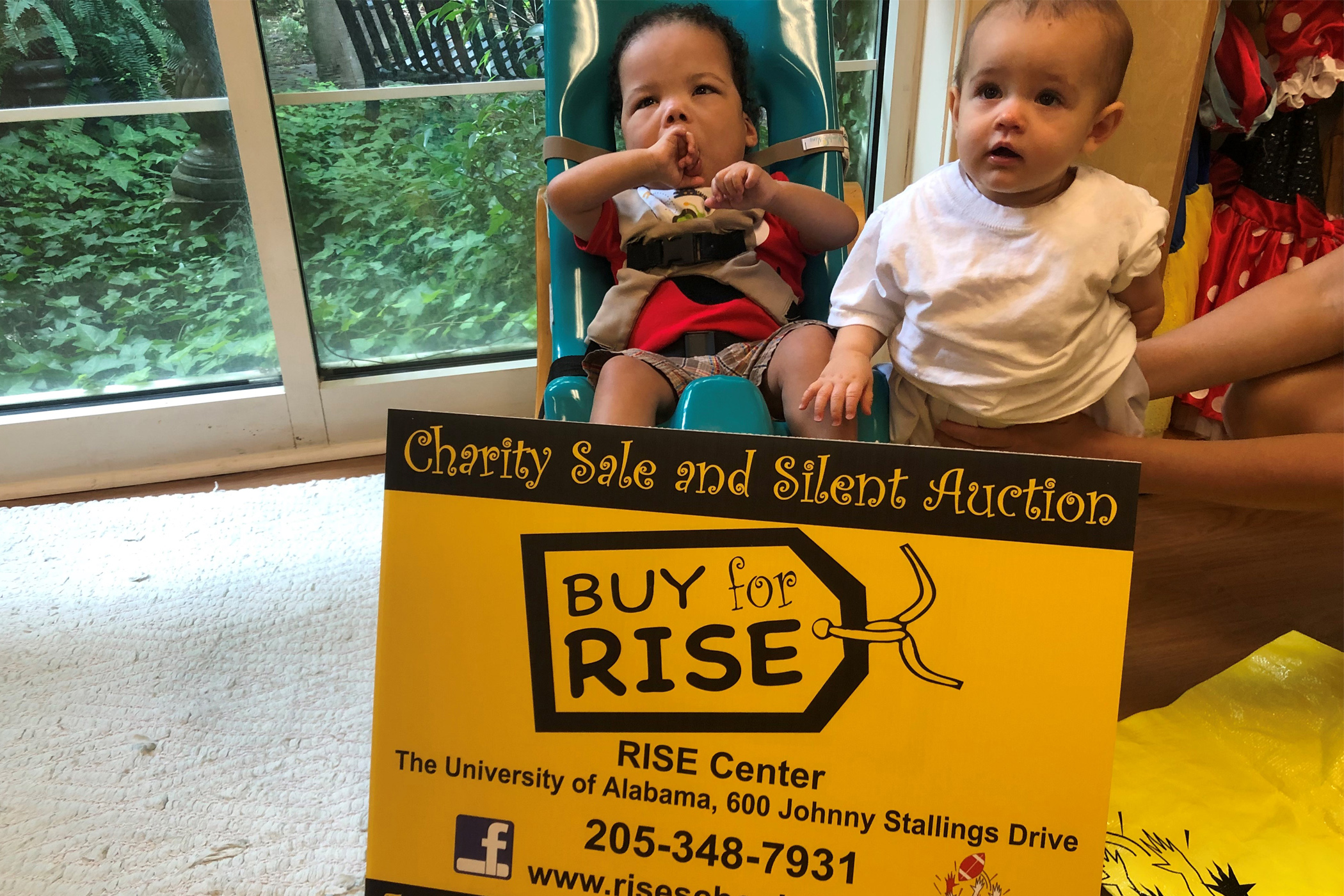 Two young children with signage promoting the RISE fundraiser.