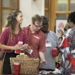 Male and female university students collect free school supplies during orientation.