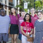 Six university students pose for a photo outdoors before student orientation