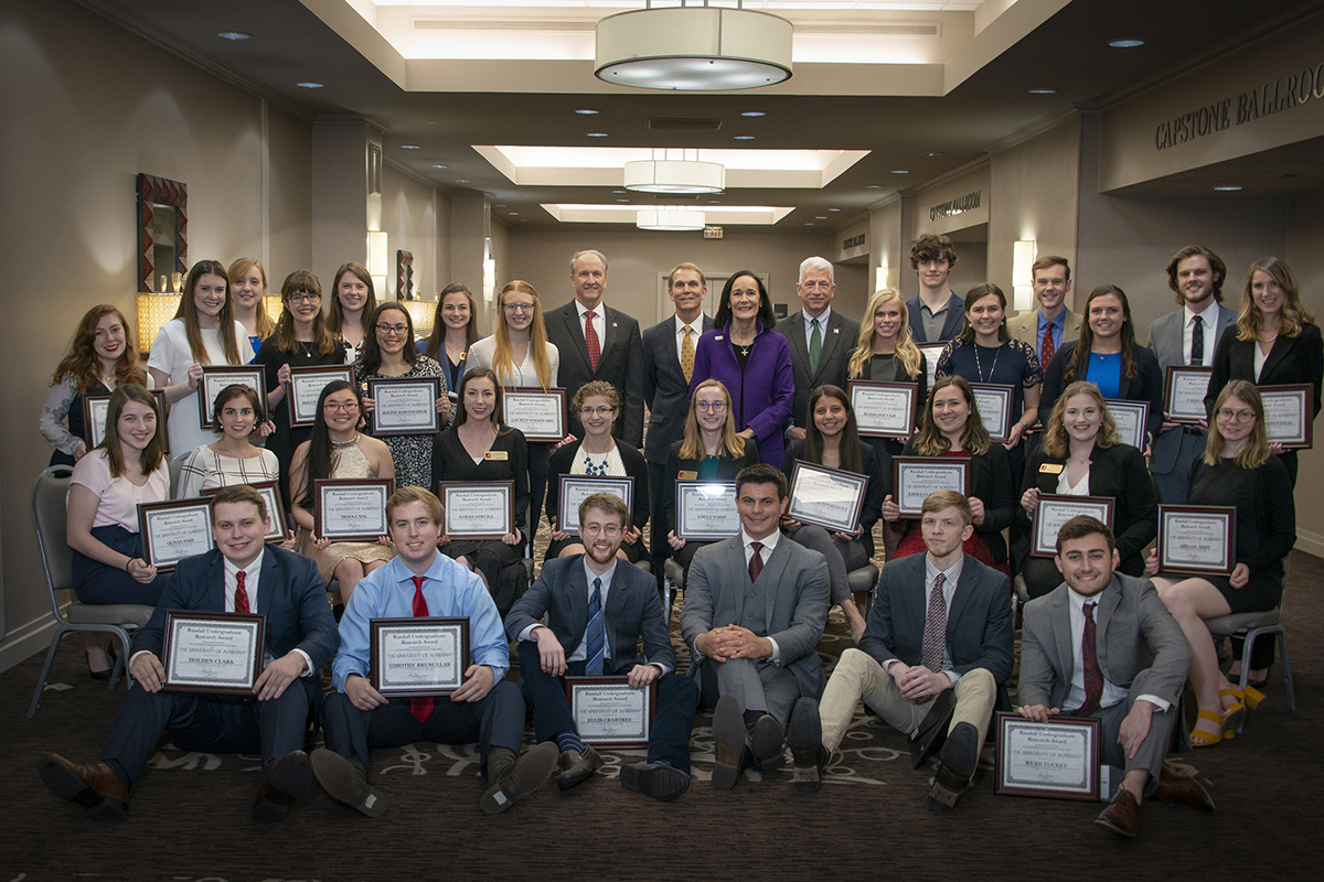 Students pose with administrators to show off their Randall Outstanding Undergraduate Research Award plaques.
