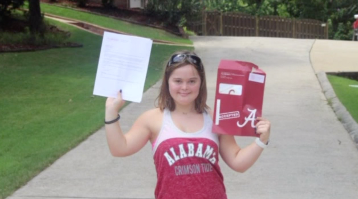 A photo of Megan Deloach holding her acceptance letter from The University of Alabama