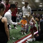 Adult playing card tricks with child dressed as cheerleader
