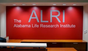 The name of the Alabama Life Research Institute in silver on a red wall.
