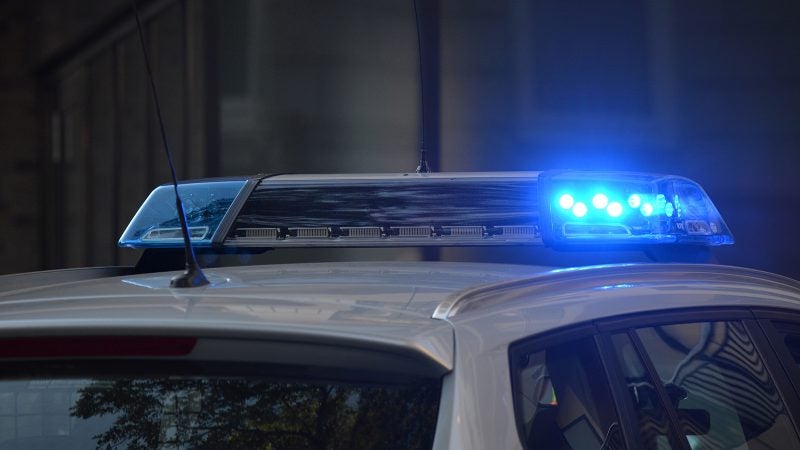 Blue police lights flash in the night.