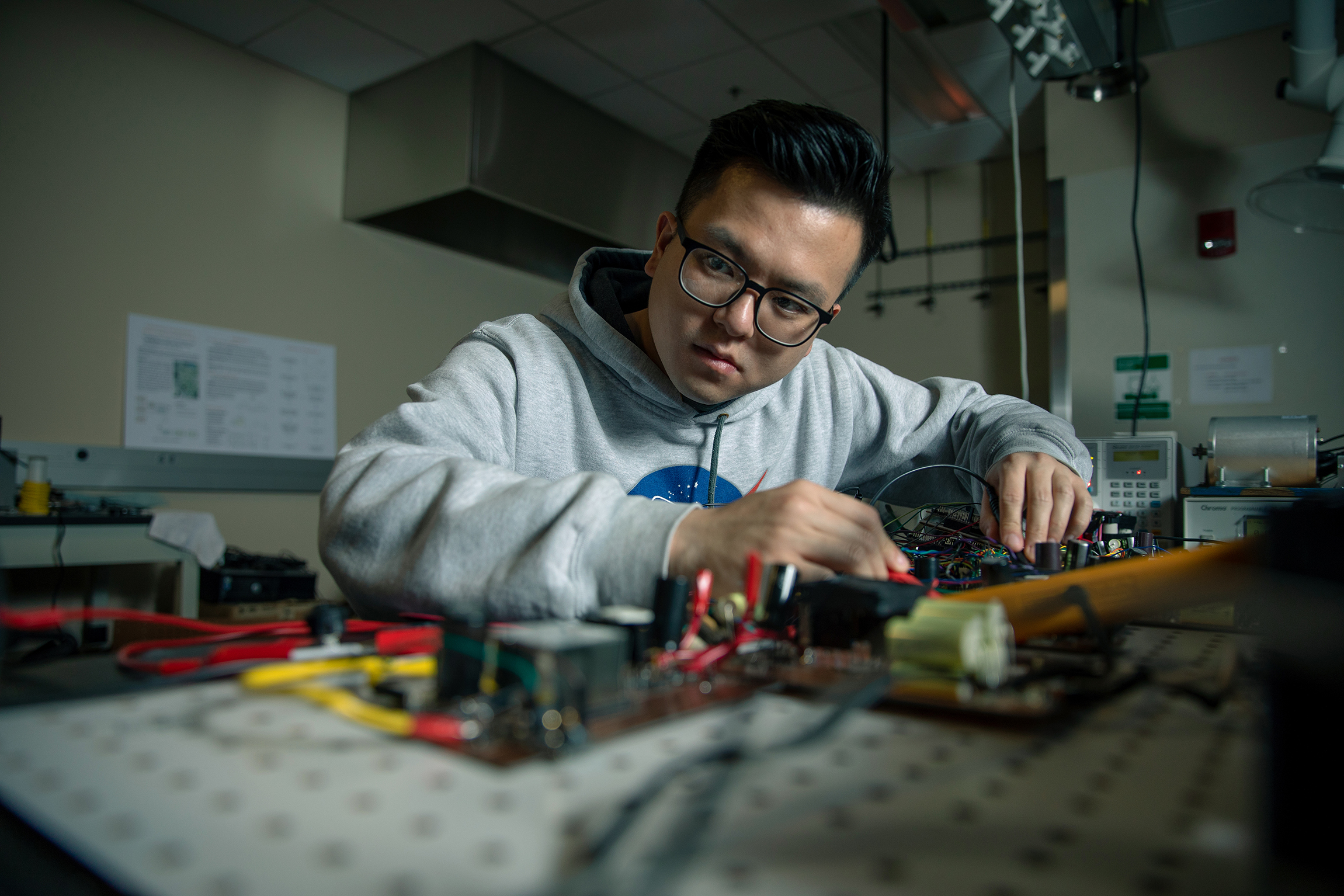 A student works with electronic equipment in a lab.