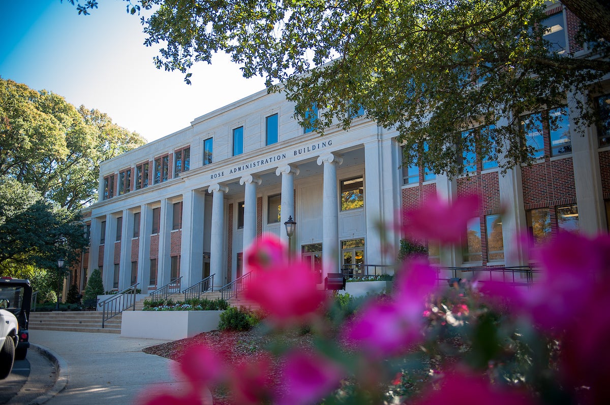 The front entrance of Rose Adminstation building framed by azalea blooms.