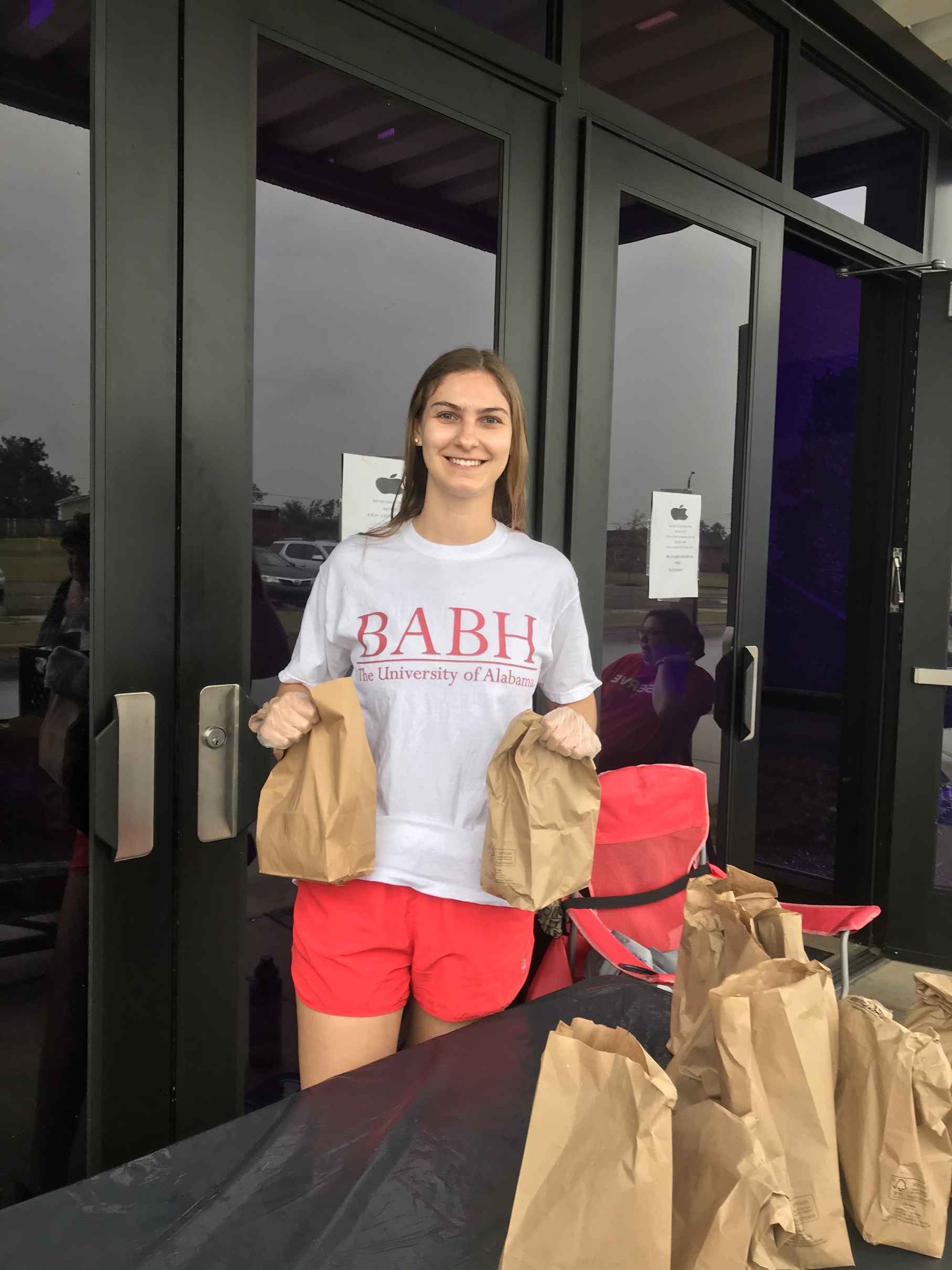 Abigail Gunter passing out bags of free breakfast and lunch to Tuscaloosa City School students