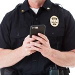 A police officer holds a cell phone