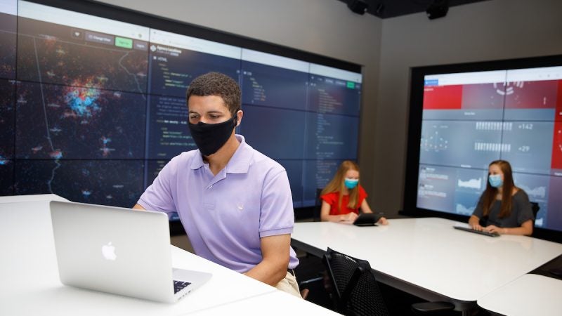 Three students in a lab wearing face masks.