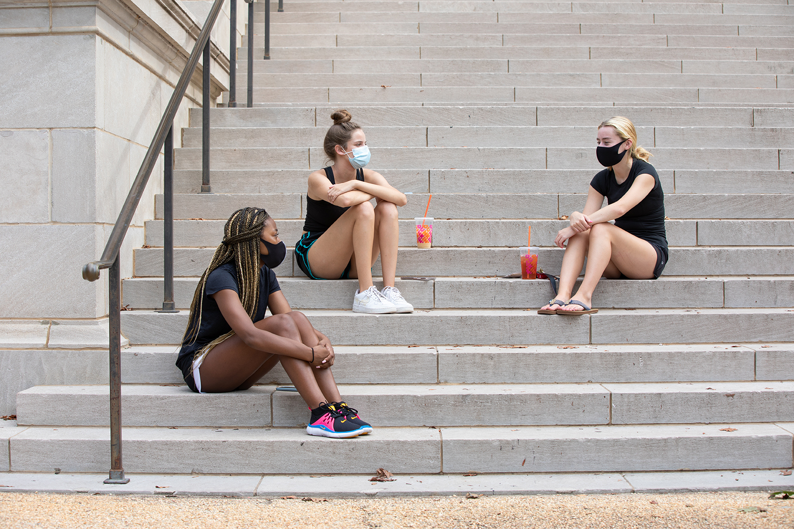 three female students sit on the steps of Gorgas Library talking