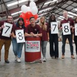 Students stand in front of a barrel at the 2019 Beat Auburn Beat Hunger food and fund drive result day.