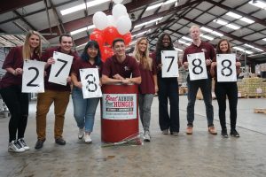 Students stand in front of a barrel at the 2019 Beat Auburn Beat Hunger food and fund drive result day.