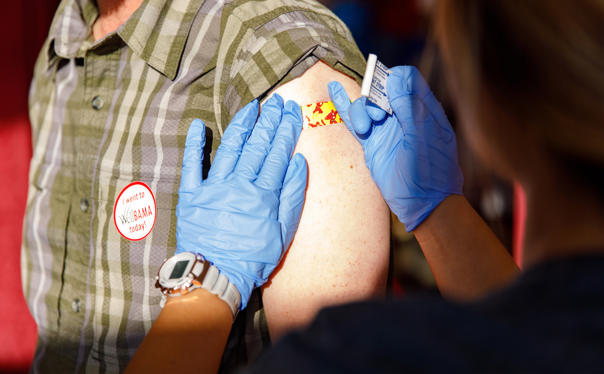 A nurse putting a band aid on a person following a flu shot.
