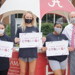 Dr. Bell poses for a picture with three female students for the "Capstone Caught Caring" campaign.