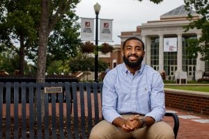 Zachary Collins sits on a bench on campus. 