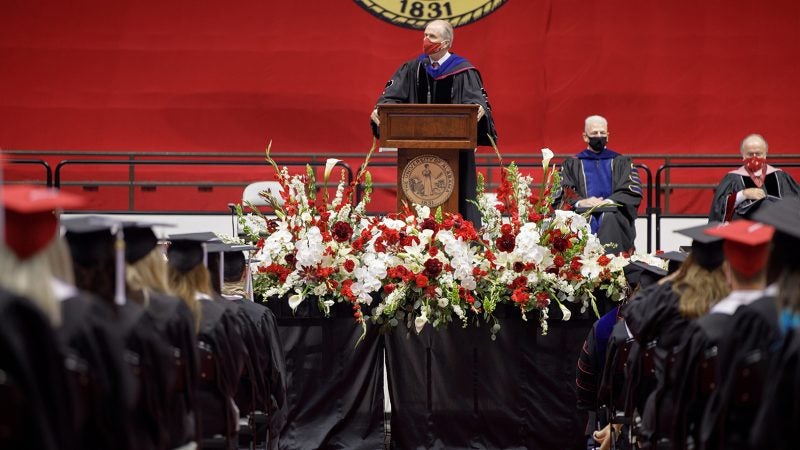Dr. Bell speaks to students on stage at summer commencement.