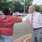 Dr. Bell rubs elbows with a female student during the "Capstone Caught Caring" campaign.
