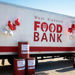A display of the West Alabama Food Bank collection truck and barrels.