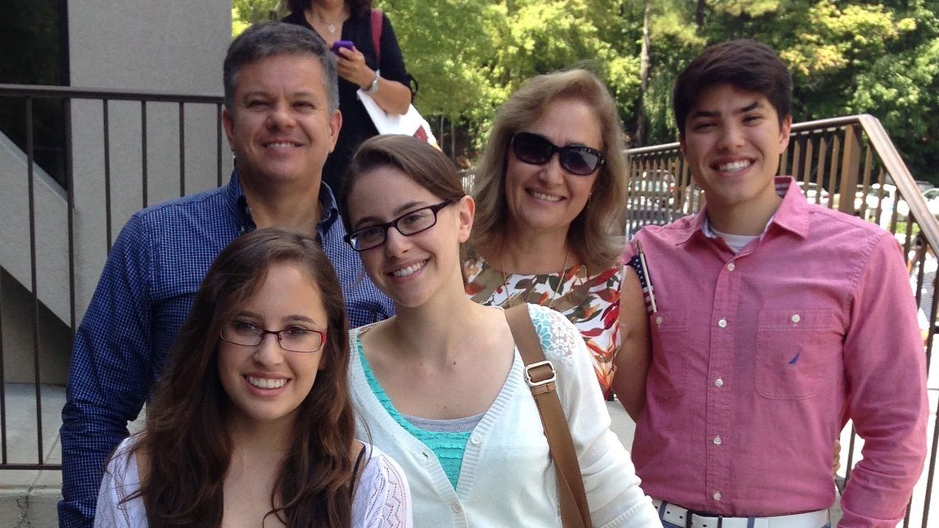 The Carrasquilla family (Laura in front with blue dress, Tatiana with green dress, Juan with salmon shirt in the back, their father Carlos in the blue shirt and mom Liliana wearing sunglasses) at their U.S. citizen naturalization ceremony in 2016.