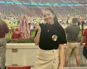 Female UA student cheers on the football team.