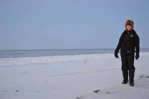 Leigh Mayberry stands in front of the Arctic Ocean.