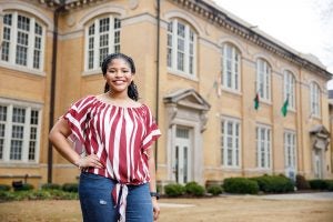 A UA student stands in front of B.B. Comer Hall. 