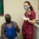 A nursing student and patient giving a thumbs up after the patient received the coronavirus vaccine