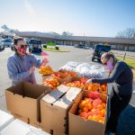 UA students fill boxes with oranges.
