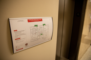 A building emergency plan hangs on a wall near a elevator