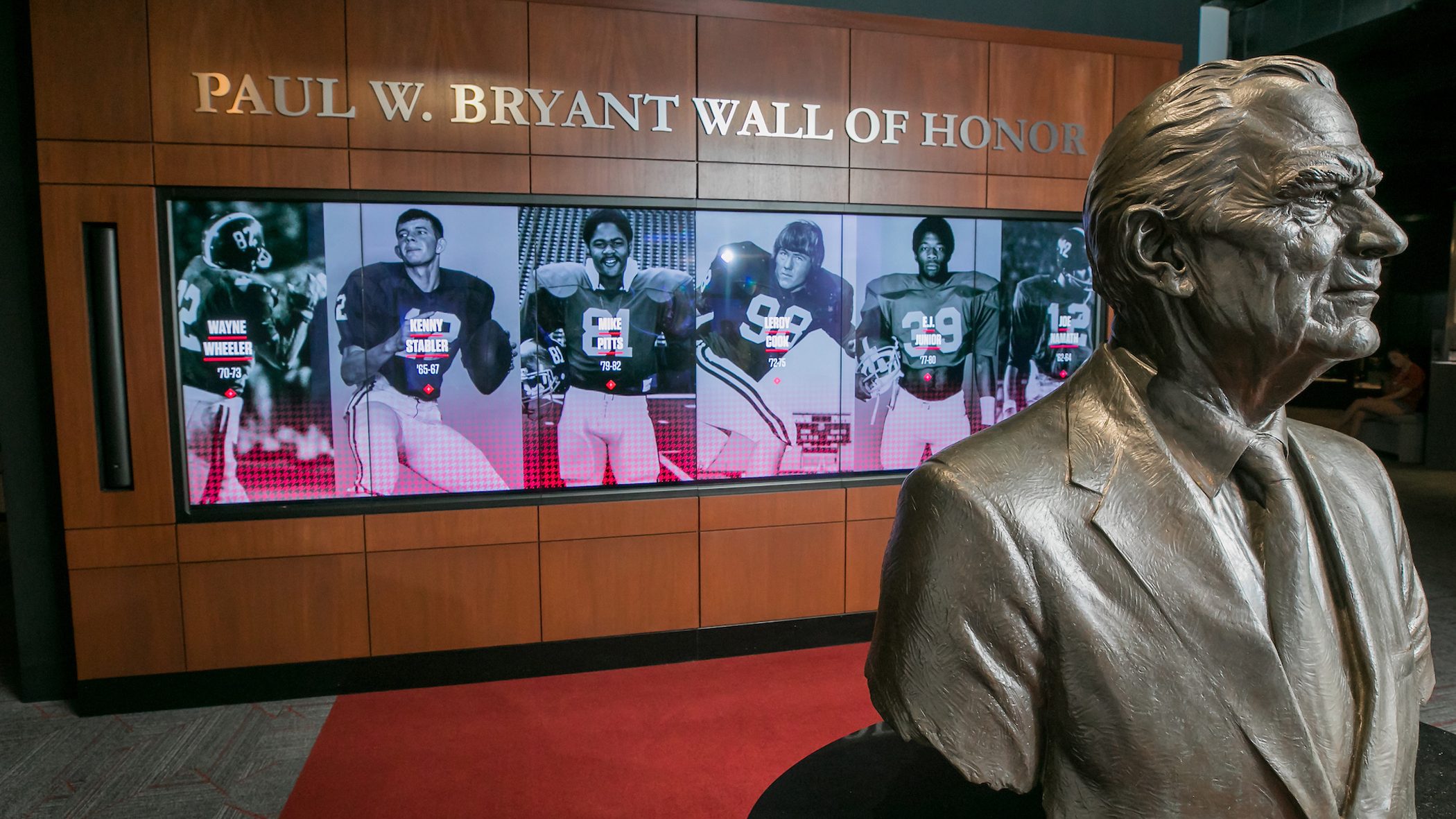 A bust of Paul Bryant in front of a digital display in the Bryant Museum