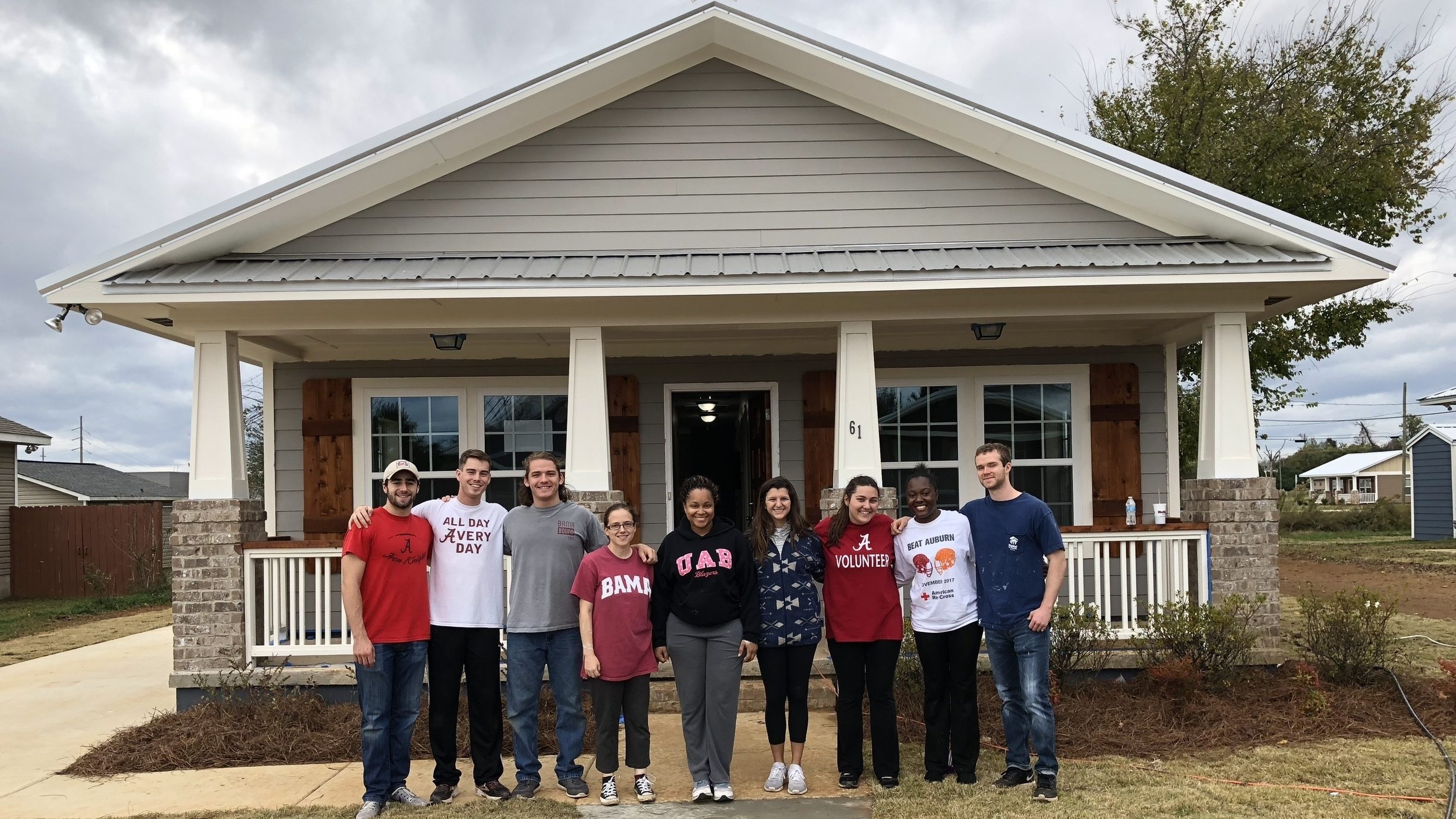 UA Habitat for Humanity students standing in front of a completed home.