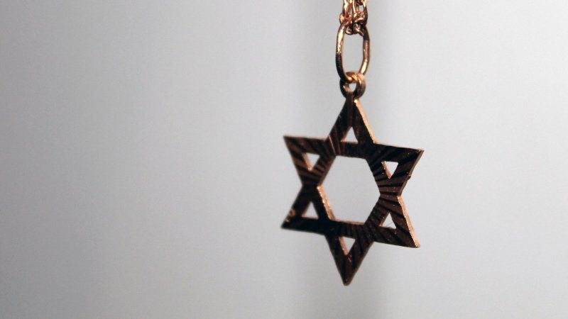 close up photograph of a gold star of david pendant