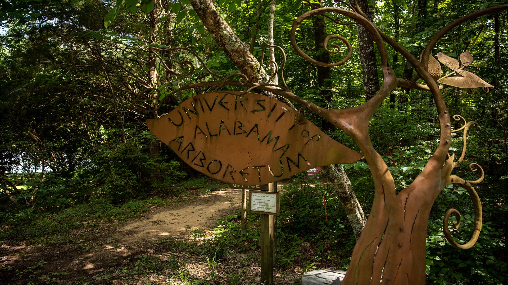 A sign says University of Alabama Arboretum out of metal.