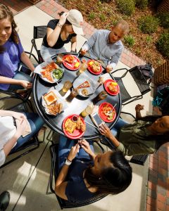 a view of six students eating on the terrace at Lakeside Dining Hall