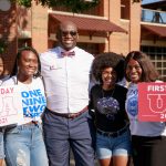 Dr. Myron Pope poses for the camera with four students, two of which hold signs reading "First Day UA" 2021