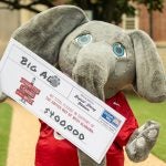 Big Al holds a giant pledge card for the United Way that reads "$400,000