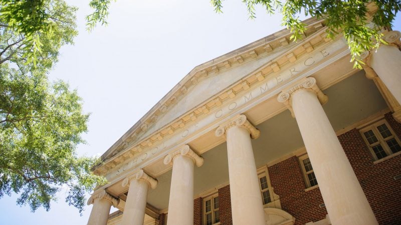 photograph of the exterior of a building with the words School of Commerce etched on the exterior