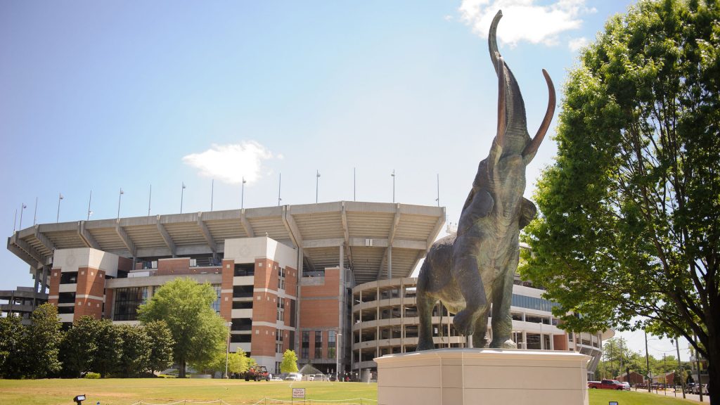 photograph of the bronze Tuska elephant statue with Bryant Denny Stadium in the background