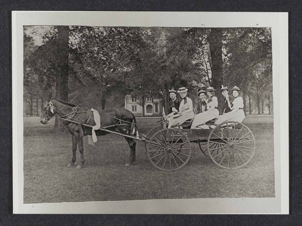 Six people in a horse drawn carriage.