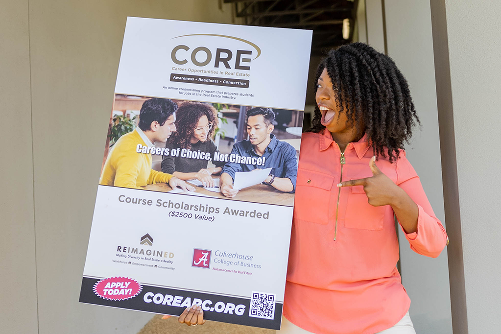 A woman holding a poster about CORE