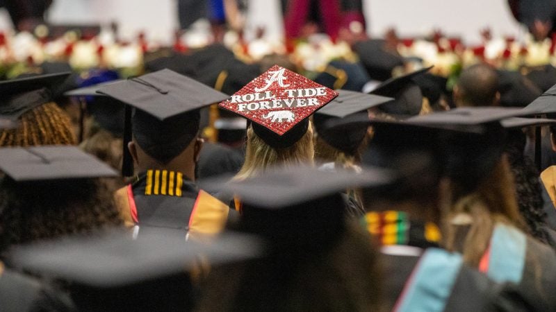 A decorated graduation cap that says Roll Tide Forever during spring 2021 commencement
