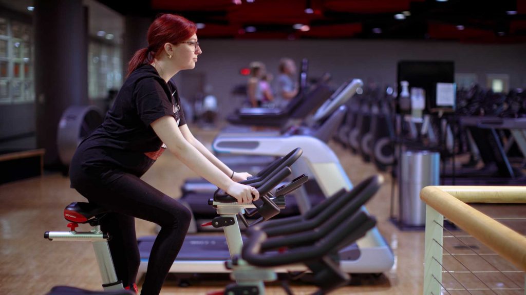A woman works out on a bicycle machine.