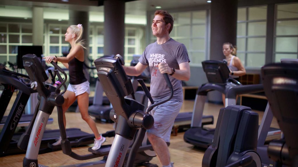 Students work out on an elliptical machines.