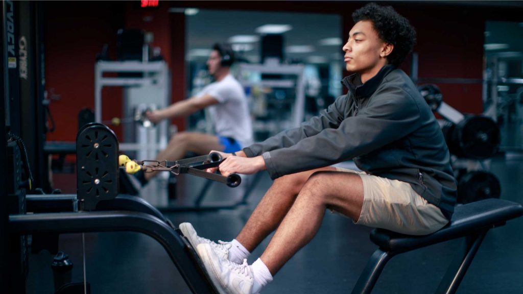 A student sits on a rowing machine.